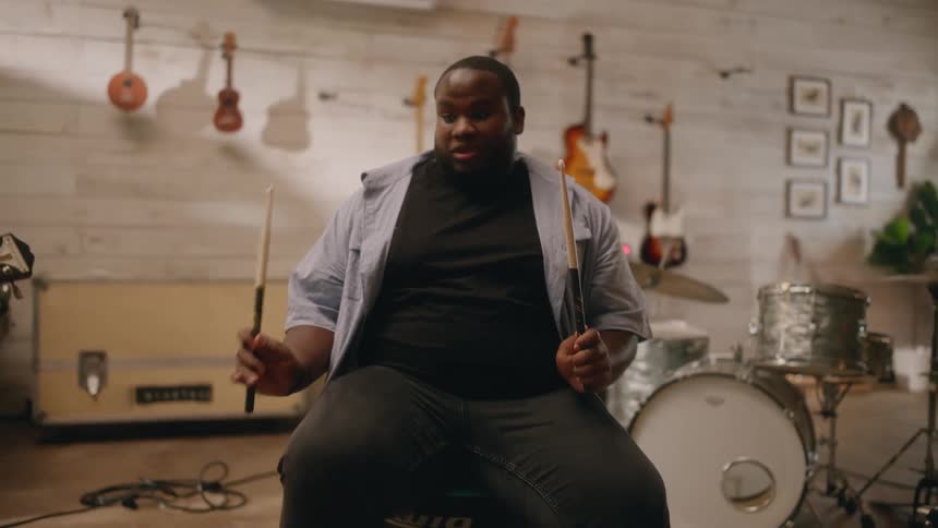 A man is playing drums on his knees
