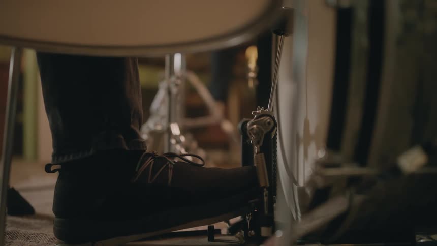 Closeup of a persons foot pressing a bass drum pedal