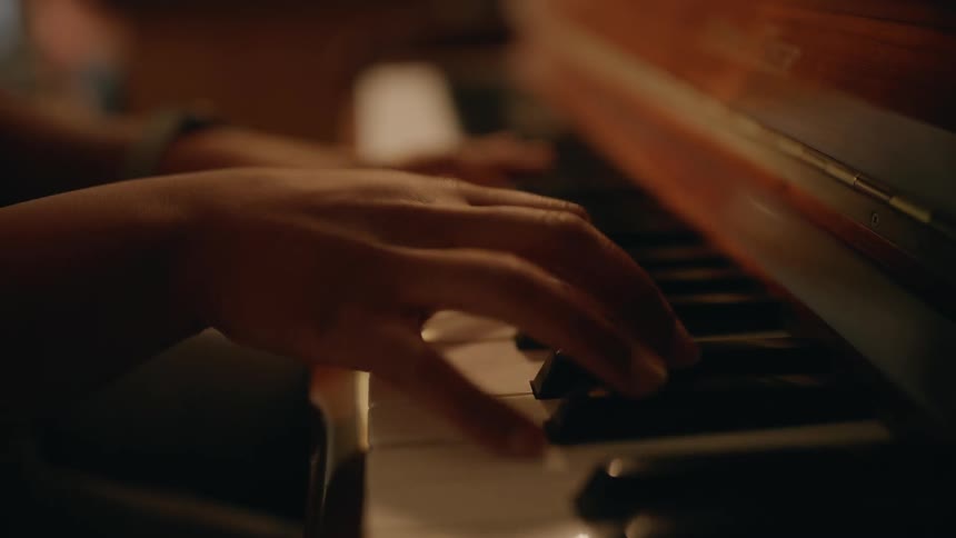 A black woman plays a piano