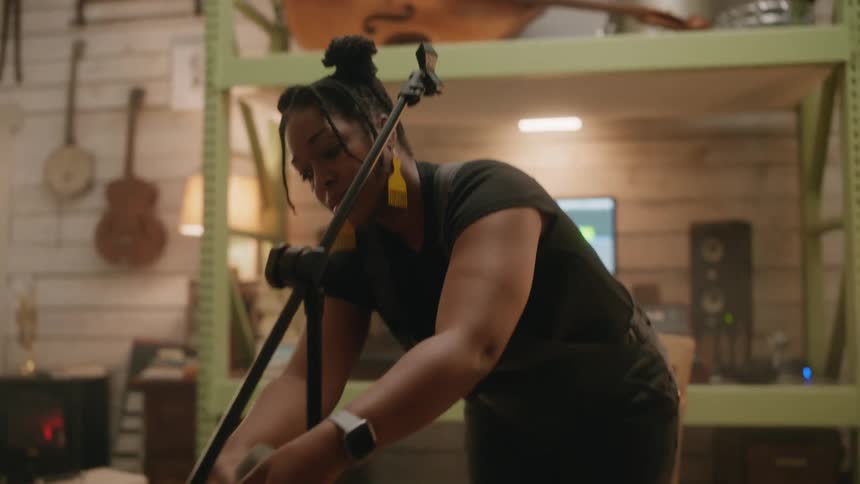 A woman is setting up a microphone in the studio