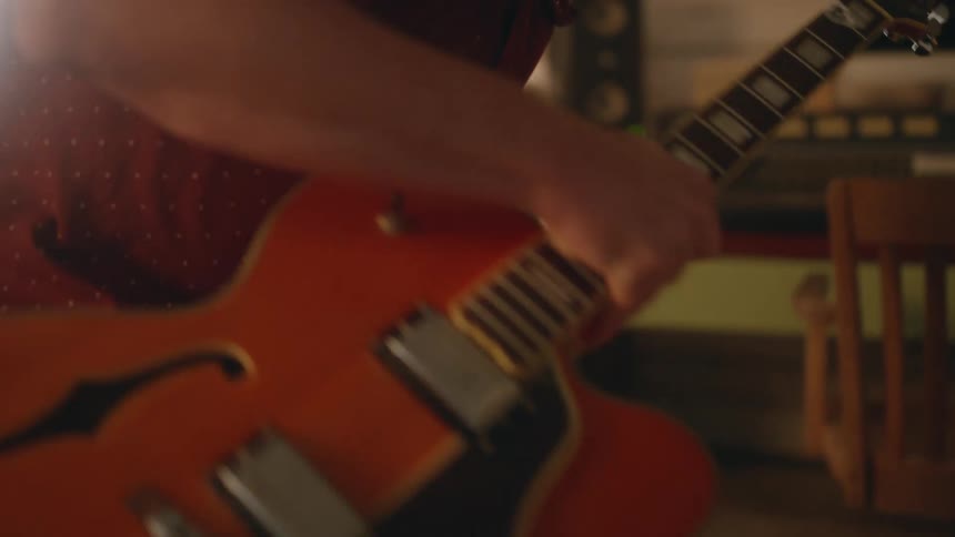 A musician takes a guitar out of a case to play it