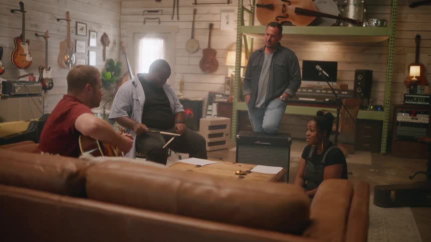 Musical group of four people rehearsing in a music studio