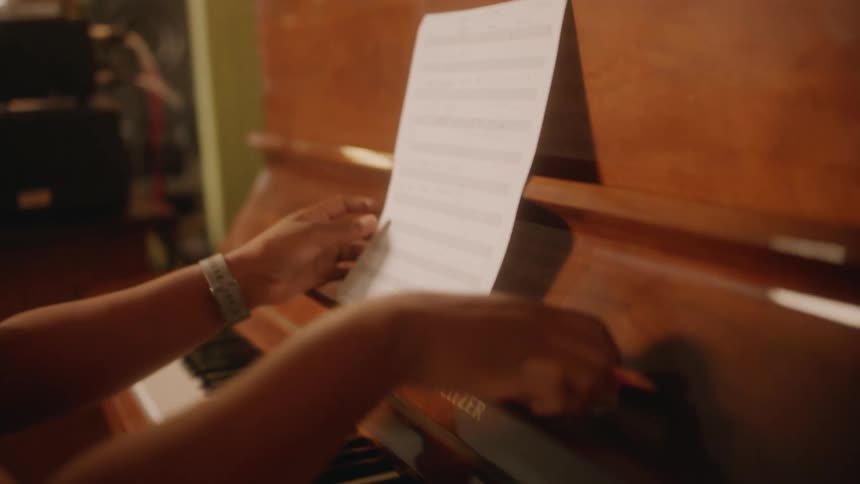 A woman sitting at piano composes a song