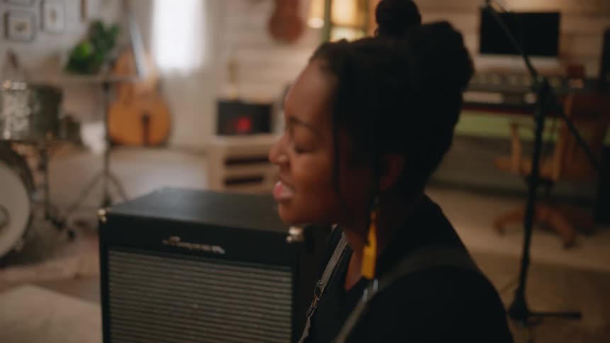 A black woman sings while a black man taps his drumsticks