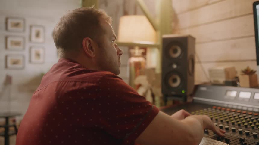 Man concentrated at a table with a music mixer