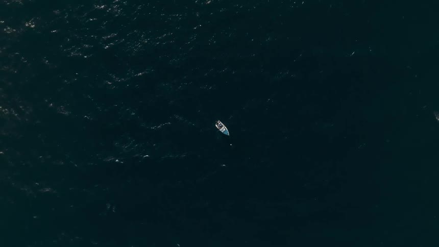 An aerial clip of a boat in the middle of the sea