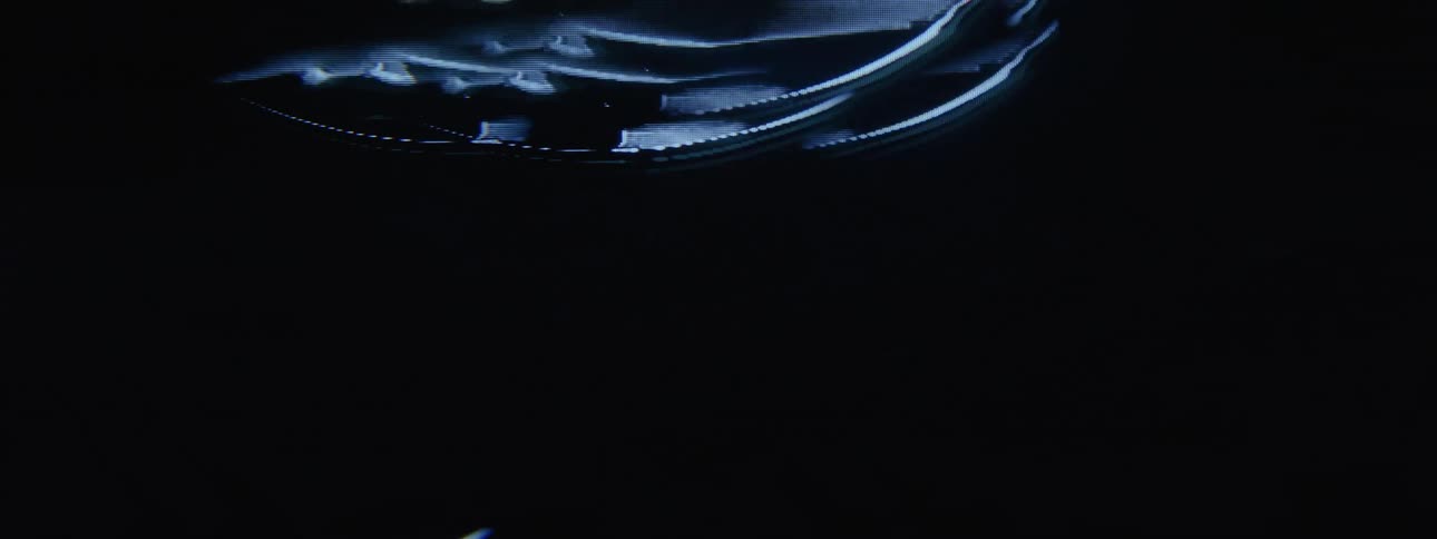 A flickering and distorted circular image ascends on a display screen