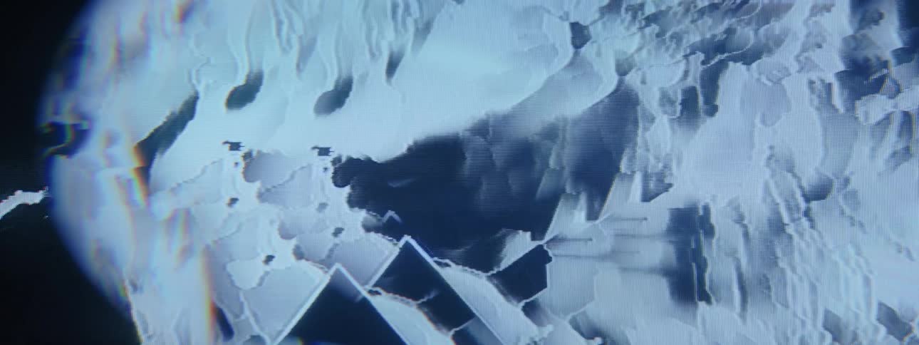 A closeup of a blue screen with a distorted triangular shape moving up