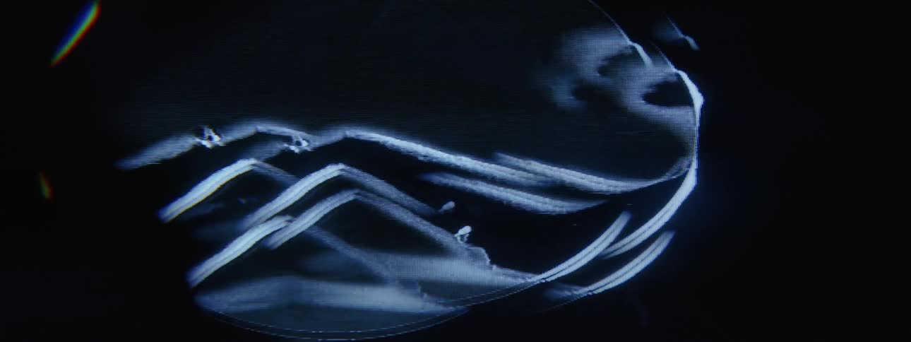 Bright light effects flow through ovals rising against a black background