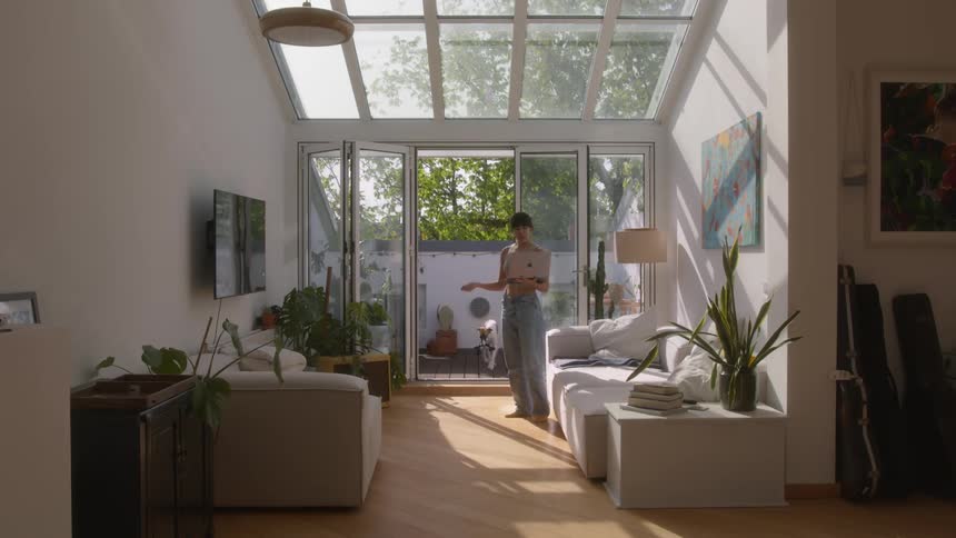 A woman on a video call through a laptop in a modern bright living room