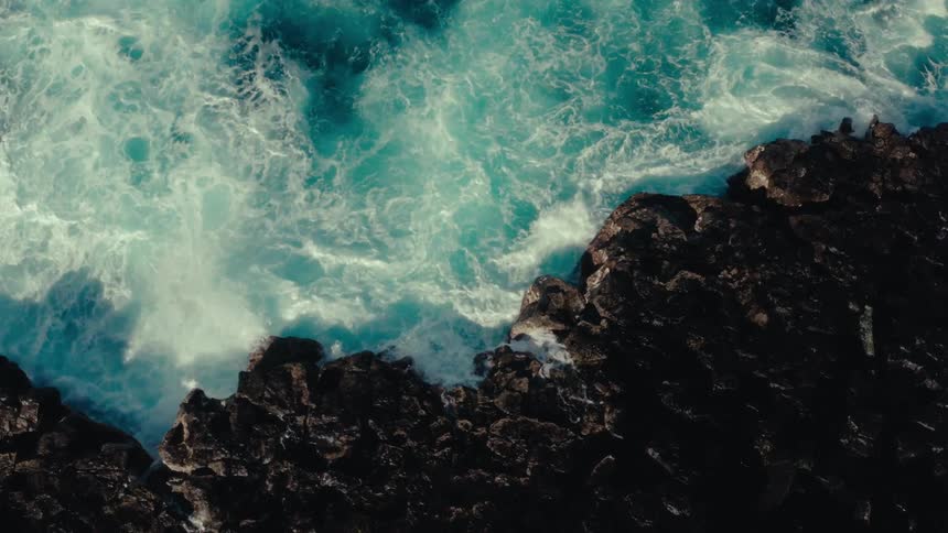Foamy waves crashing on the rocky shore