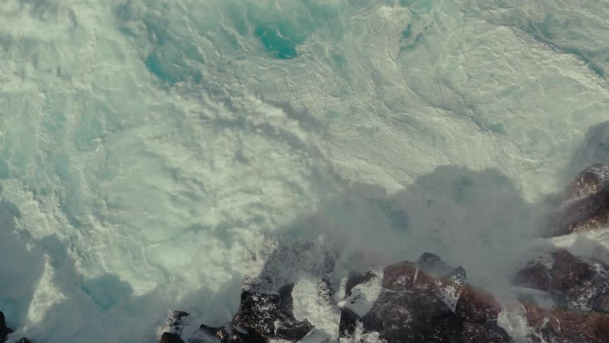 Waves crash against the rocks on the shore