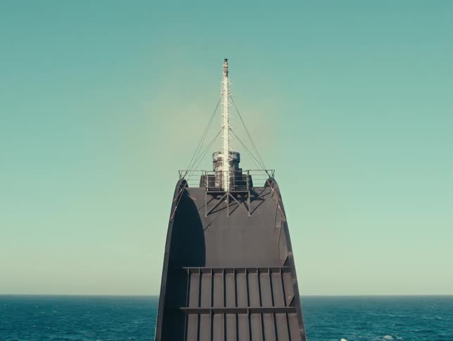 Machinery containing cables attached to a central column tower over ocean