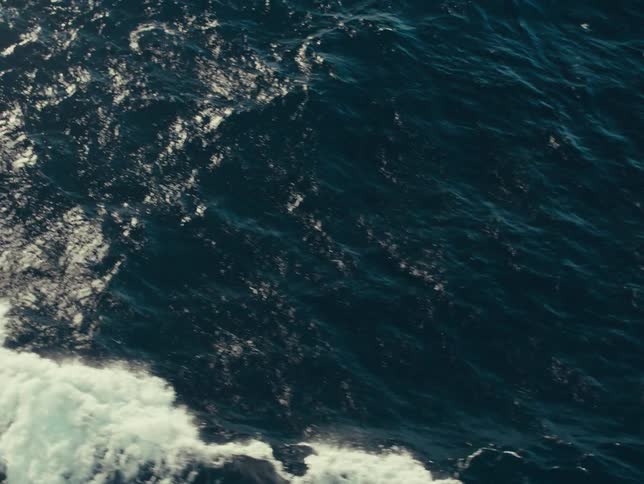 Waves from a wake spread across an ocean