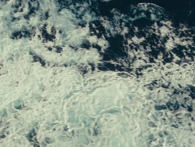 Some waves on the surface of the sea making white foam