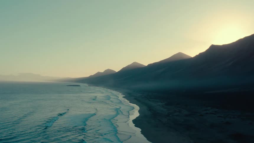 Aerial landscape of a desert beach with mountains on the coast in a morning