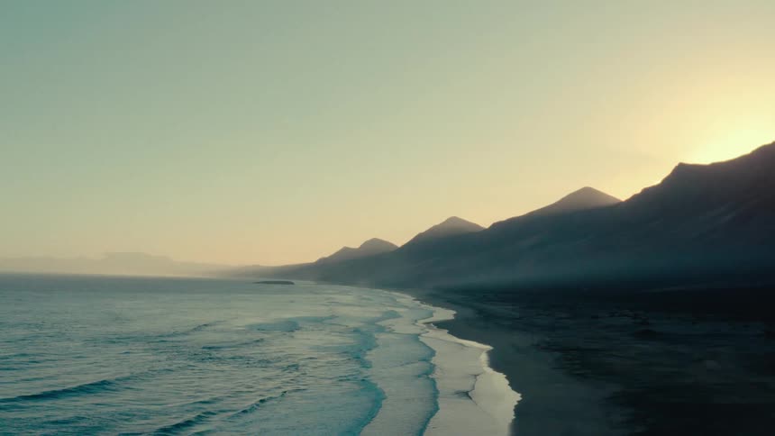 The sun is rising on the shore