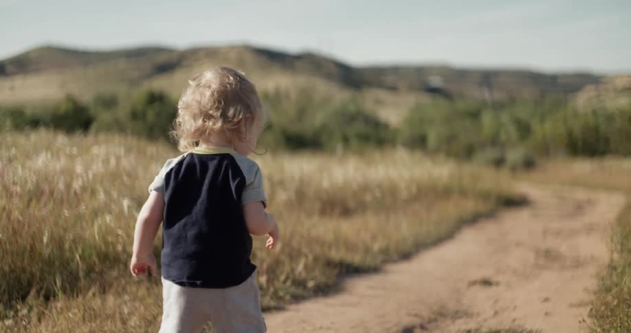 Toddler walking down a dirt path