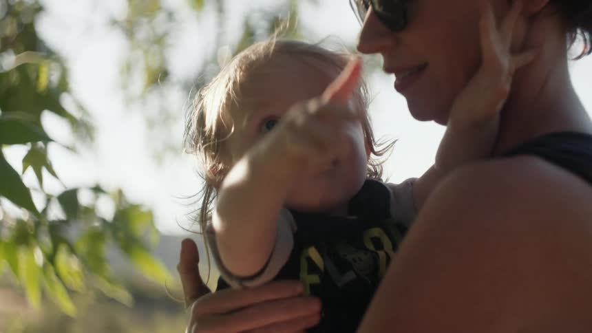 Woman holding a toddler that is pointing