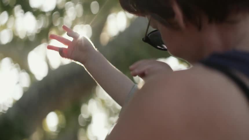 A woman and her child pick berries from a tree