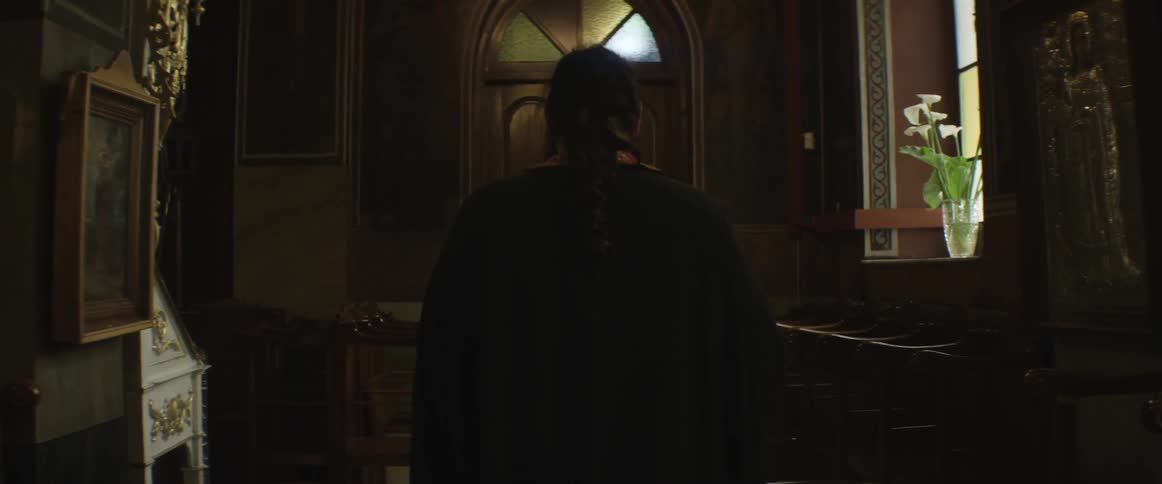 Person walking towards a door in a hall