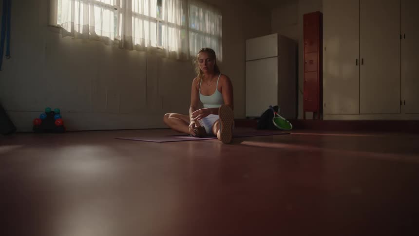 Woman stretching her legs indoors