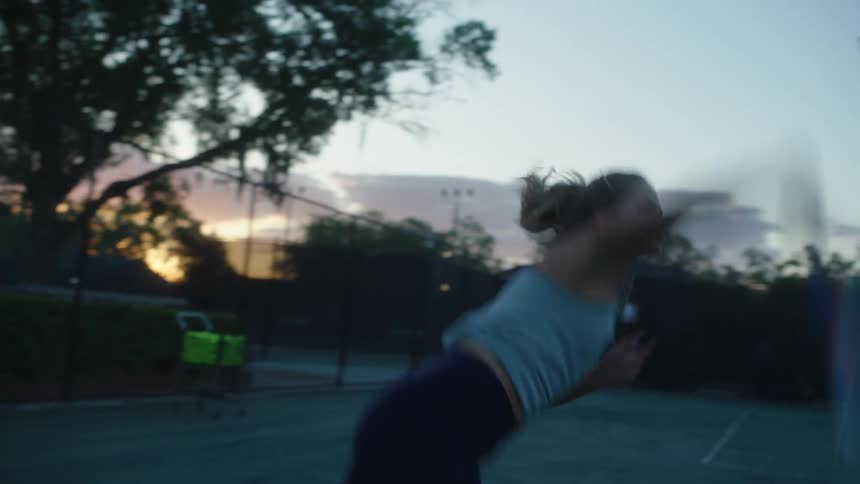 Woman with a racket throwing a ball and playing tennis
