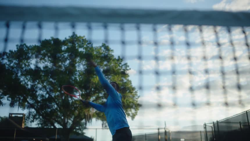 A man hits a tennis ball multiple times on a court