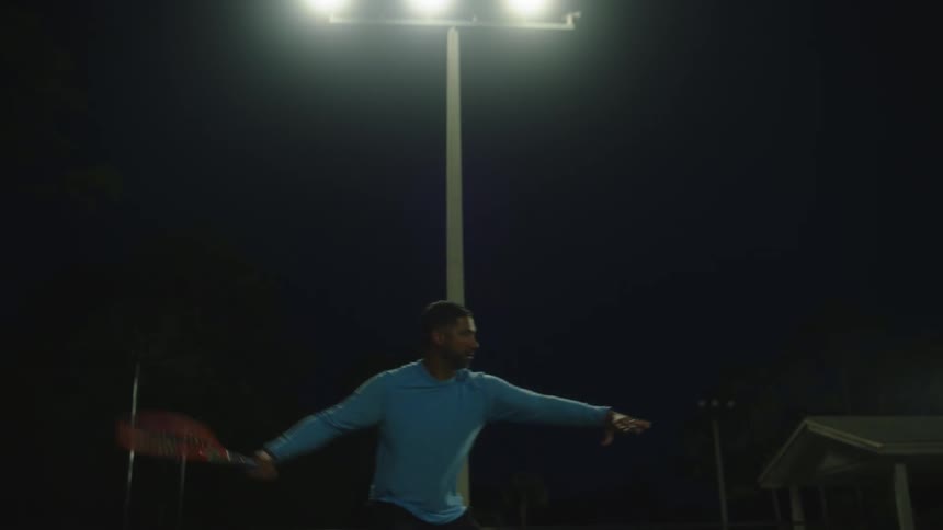Tennis player bounces on his feet before returning tennis ball during night game