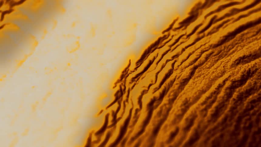 Close up of a bright yellow brown liquid expanding in ripples