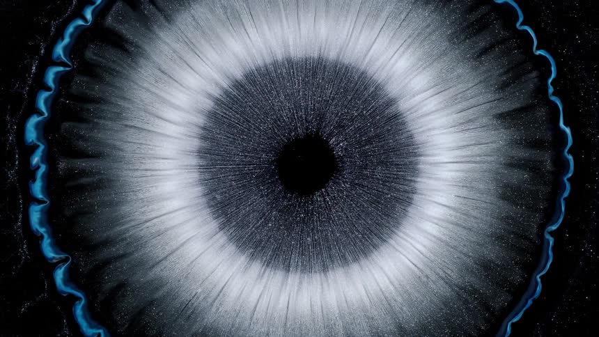 Close up of an expanding blue and white circular shape resembling an eye