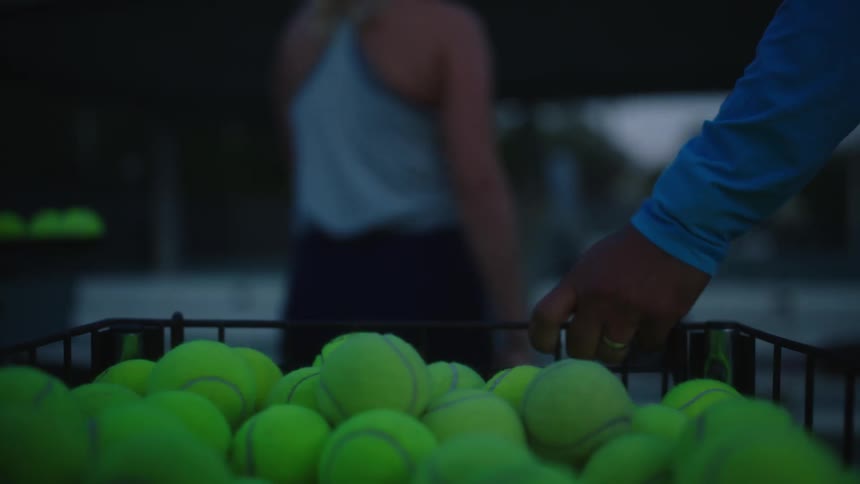 Tennis ball basket pulled on to a court for practice