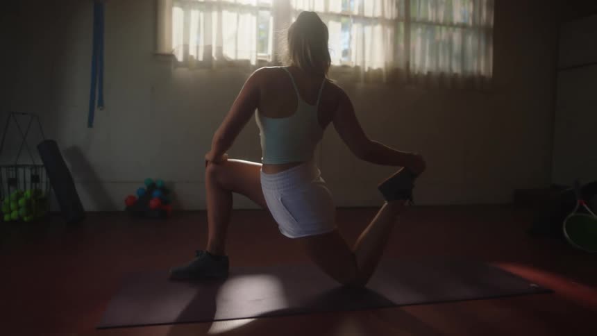 Woman stretching her legs indoors