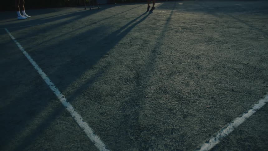 Legs of two people on a court playing tennis