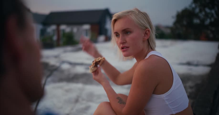 Man and woman sitting eating pizza in an openair place
