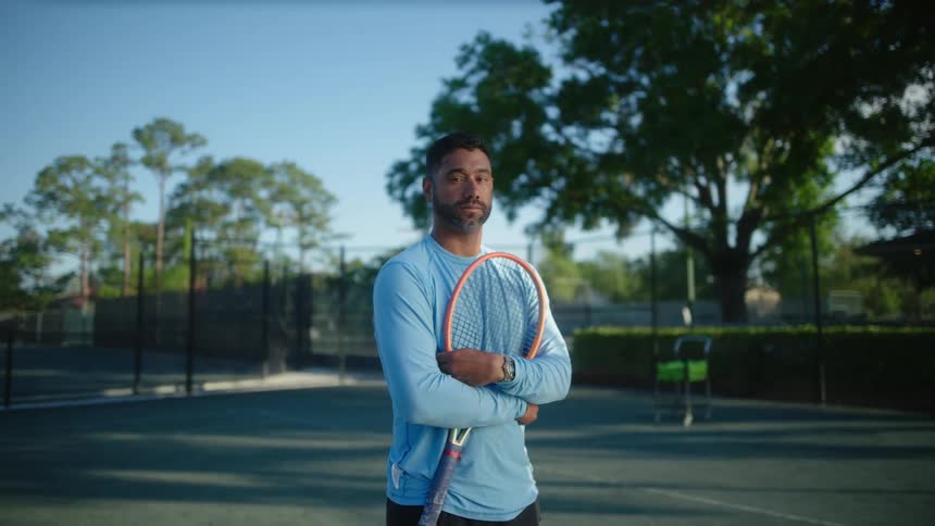 A man is holding his tennis racquet on the court
