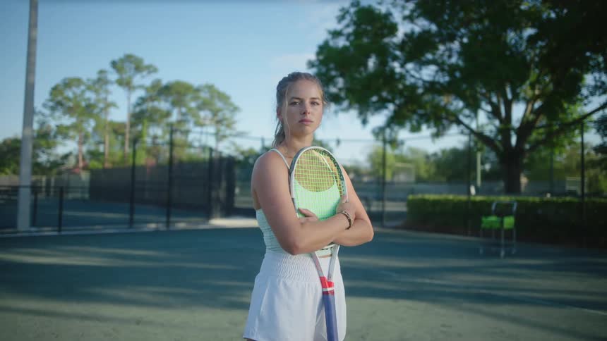 Woman hugging a racket on a tennis court