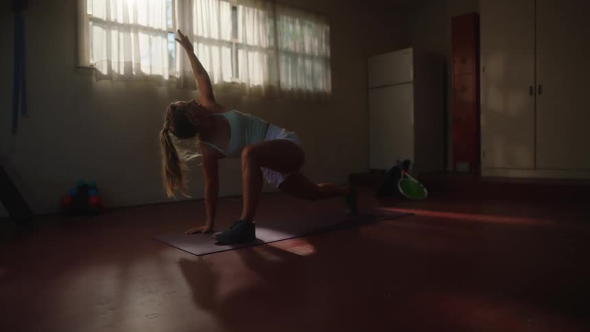 A woman is doing yoga in a dark room