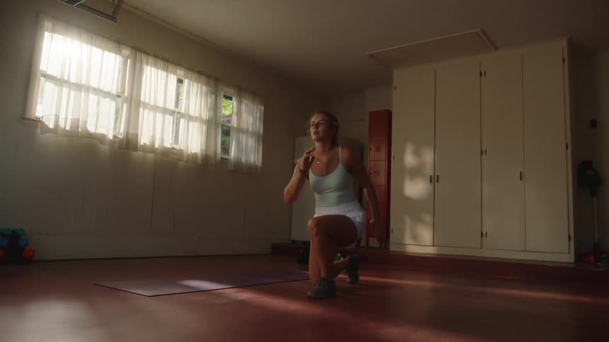 Woman in a room doing jumping squats