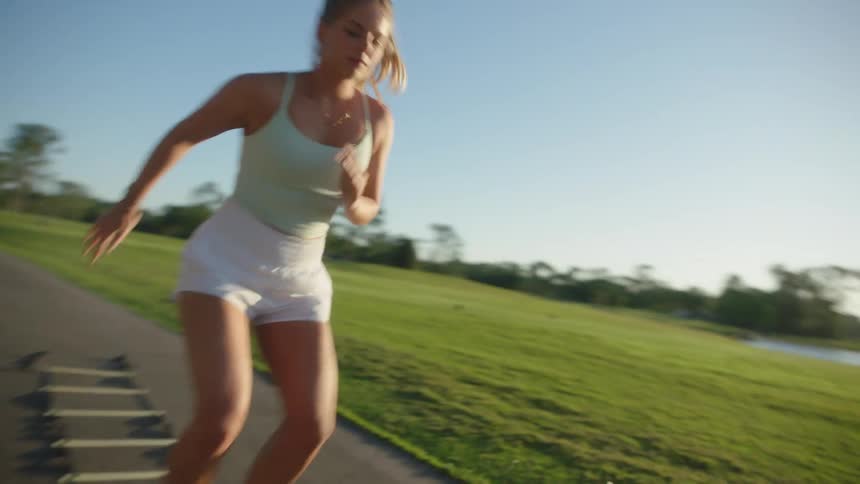 Woman in a park running through cardio educational obstacles