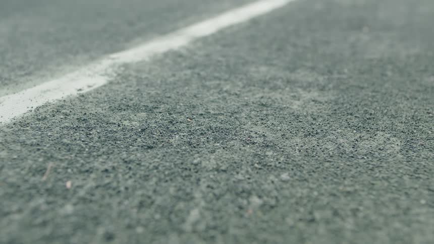 A tennis ball bounces close to a painted line on a court