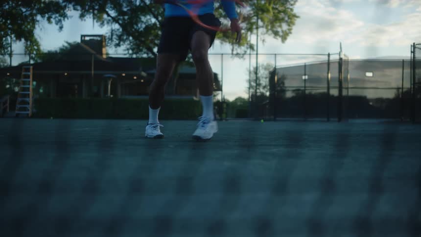 A man hits tennis balls on an outdoor court