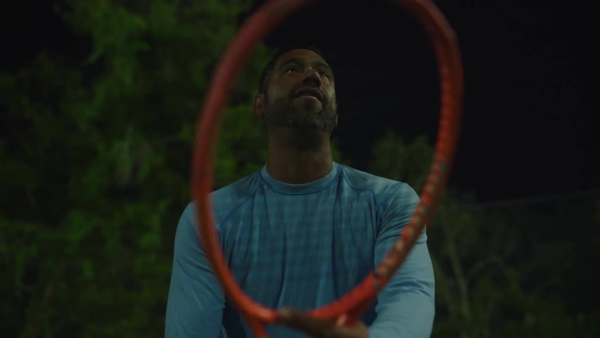 A tennis player holding a racket waits for the game to start