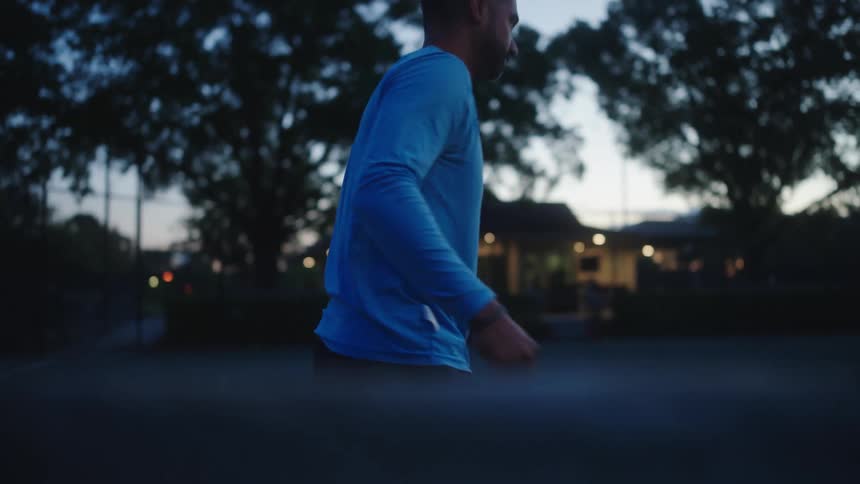 A tennis player stretches on the court before practice