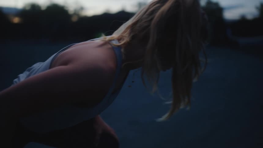 A white woman stretches on a tennis court