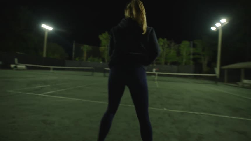 Woman hitting tennis balls on a court