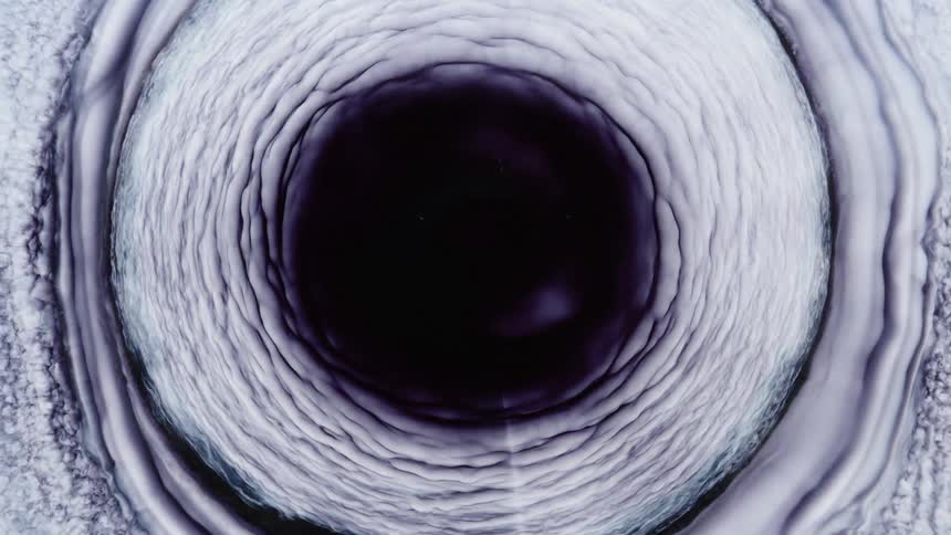 White and black layers expand from the dark center of mixture