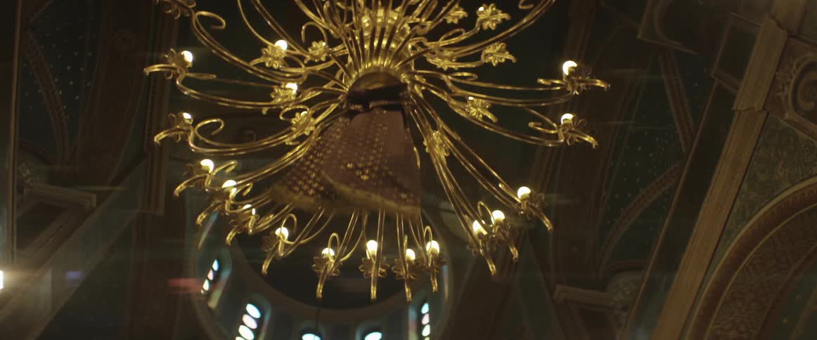 A view of a chandelier and ornate ceiling from the bottom