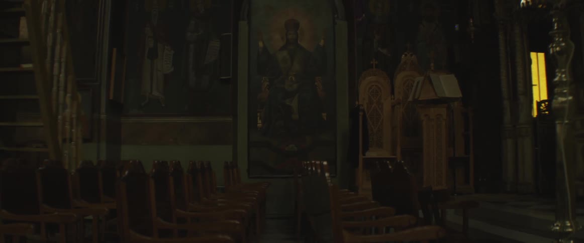 A painting hangs in a dark, quiet building