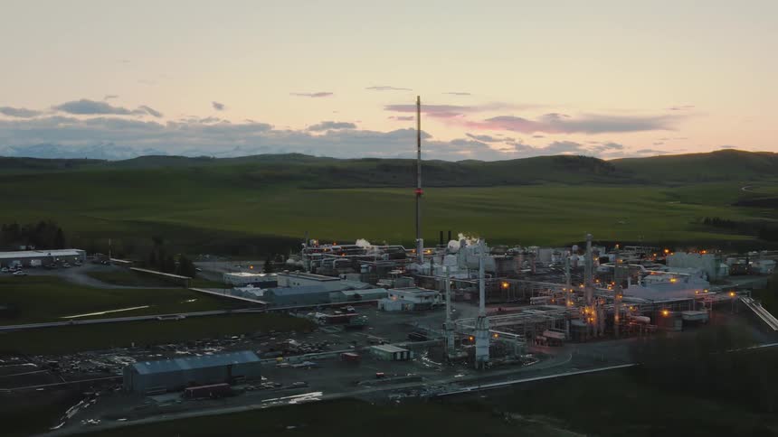 The sun is rising on an oil and gas plant in the foothills of Alberta